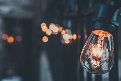 Close-up of illuminated light bulb at night