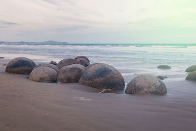 Rocks on sea shore against sky