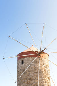 Low angle view of windmill against clear blue sky