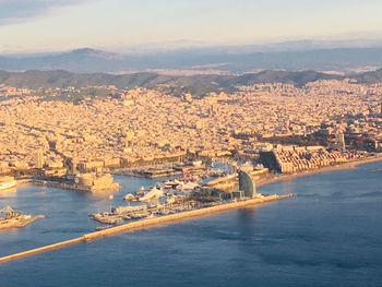 Aerial view of buildings and sea against sky