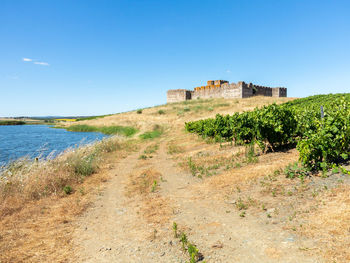 Built structure on land against clear blue sky