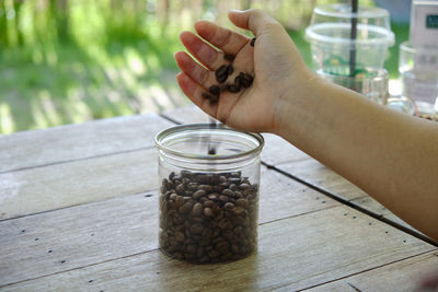 Person holding glass jar on table