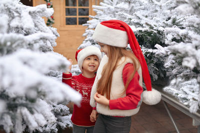 Children choose a christmas tree in a shop