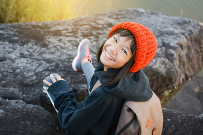 Portrait of girl sitting against lake