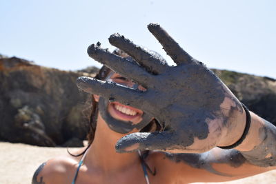 Close-up of human hand against sky