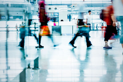 Blurred motion of people walking on tiled floor in city