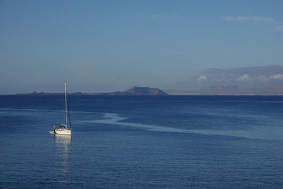 Sailboat sailing on sea against sky