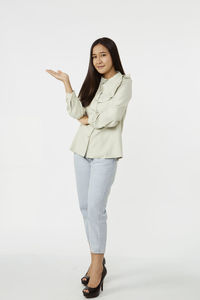 Portrait of smiling young woman against white background