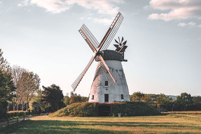 Traditional windmill on field against sky