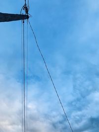 Low angle view of electricity pylon against blue sky