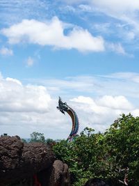 Low angle view of sculpture on rock against sky