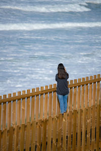 Full length of woman standing on beach against sky