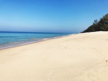 Scenic view of beach against clear blue sky