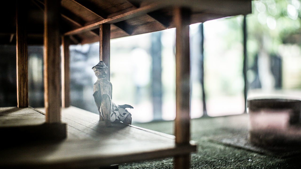 CLOSE-UP OF GLASS WINDOW ON TABLE AGAINST WINDOWS