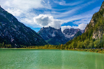 Scenic view of lake by mountains against sky