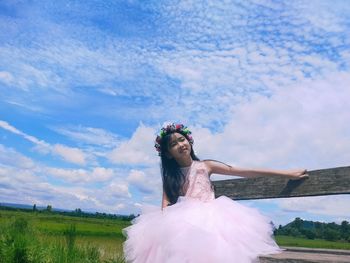 Woman standing on field against sky