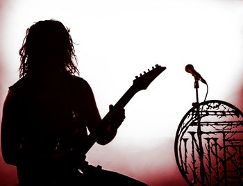 Rear view of silhouette person playing guitar