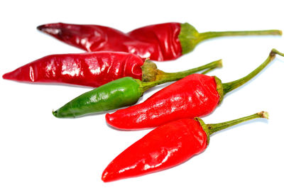 Close-up of red chili peppers over white background