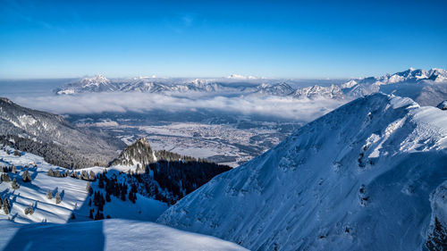 Scenic view of snow covered mountains against blue sky