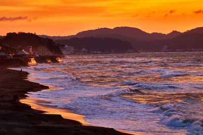 Scenic view of sea against orange sky