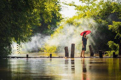 Young women walking on pier over lake