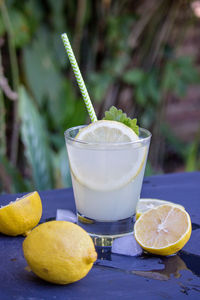 Glass of lemonade with mint and ice on a table with a lot of waste