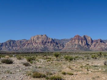 Scenic view of landscape and mountains against clear blue sky