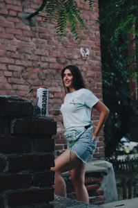 Full length of woman standing against wall