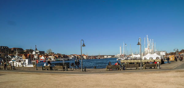 River in front of pathway against clear blue sky at flensburg on sunny day