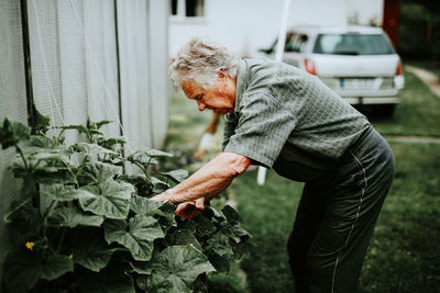 Side view of man standing by plants