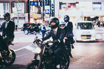 People riding bicycle on road in city