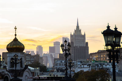 Buildings in city against sky during sunset