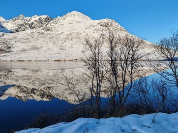 Scenic view of snowcapped mountains against clear blue sky