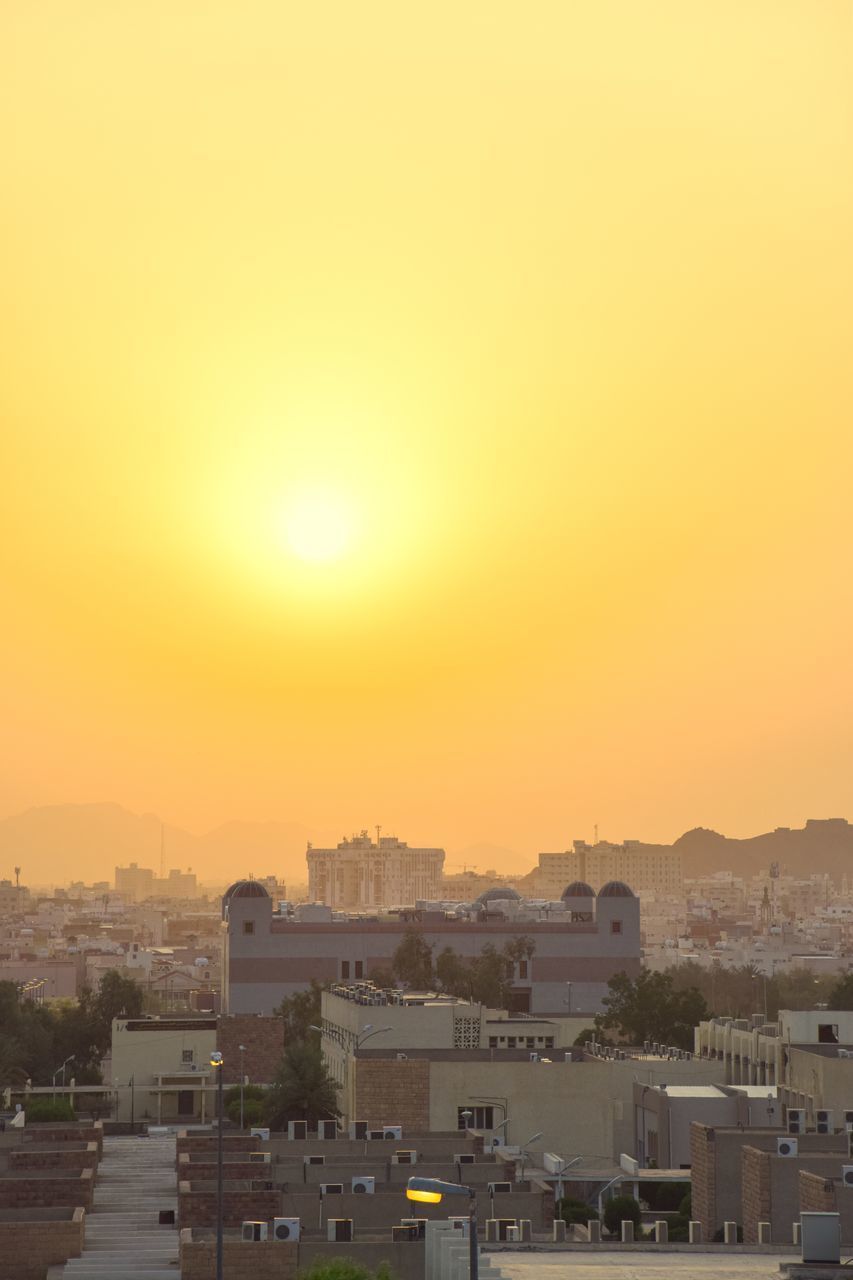 HIGH ANGLE VIEW OF BUILDINGS AGAINST CLEAR SKY AT SUNSET