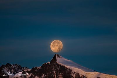 Scenic view of majestic mountains against sky at night