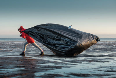 Side view of woman standing at beach