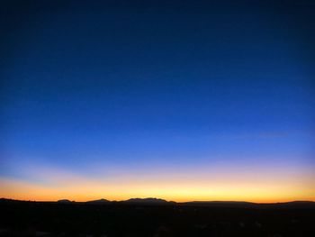 Silhouette landscape against clear sky at sunset