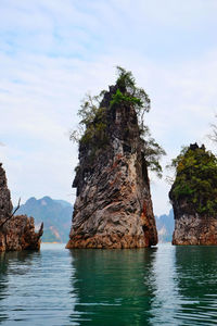 Scenic view of rock formation in water against sky