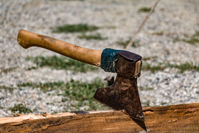 Close-up of axe in wooden plank