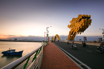 View of dragon bridge over river against sky