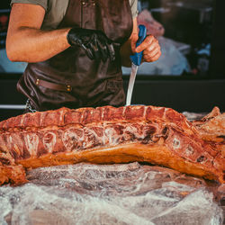 Midsection of man holding fish at market