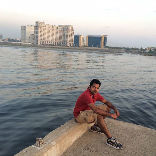 water, building exterior, lifestyles, architecture, built structure, young adult, leisure activity, full length, person, river, casual clothing, sitting, city, nautical vessel, sea, young men, transportation