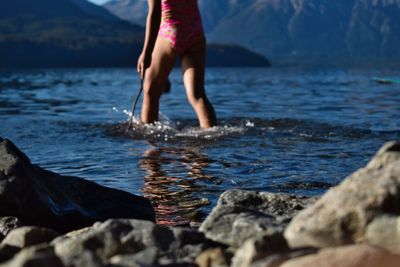 Midsection of woman walking on lake