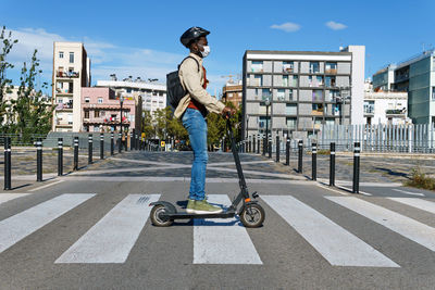 Man riding motorcycle on road in city