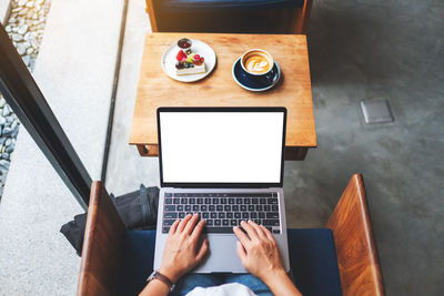 Cropped hands using laptop on table