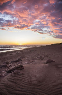 Scenic view of beach against sky during sunset