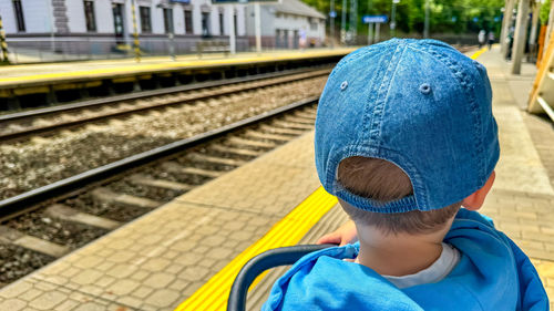 Rear view of woman standing on railroad station