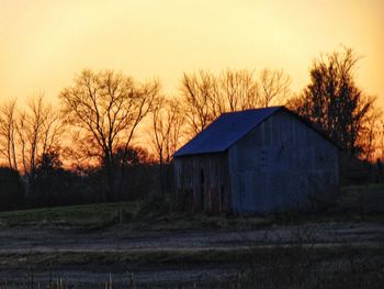 Built structure on field against sky during sunset