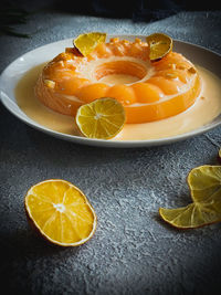 Close-up of orange pudding on table, poured with orange cheesy sauce