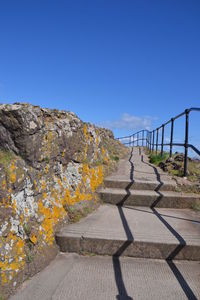 Surface level of road against clear blue sky